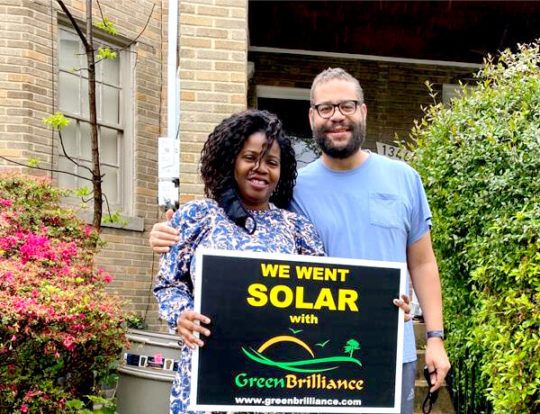 Green Brilliance couple with sign